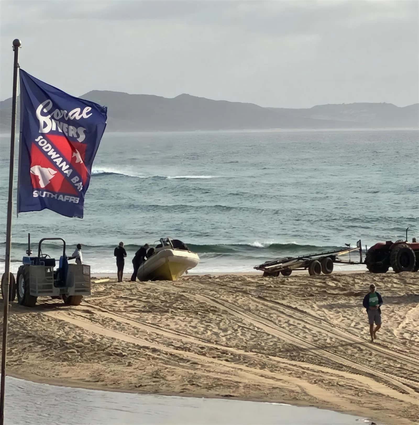 The dive boat being brought to the water at Sodwana Bay, the Coral Divers flag flying at the beach