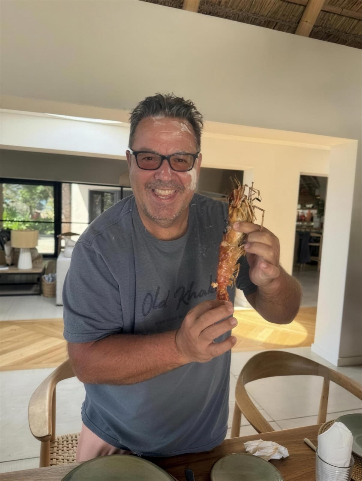 Gordon laughing over a giant prawn in the dining room of a lodge in Mozambique
