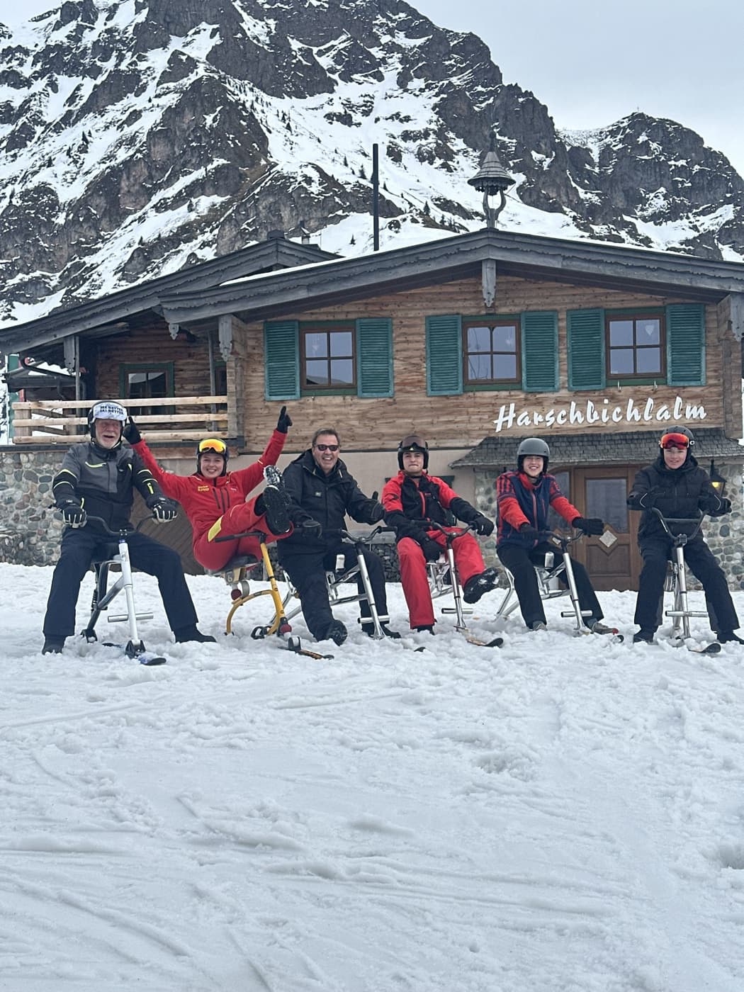 A group on snow bikes in front of the Harschbichlalm hut above St. Johann in Tirol
